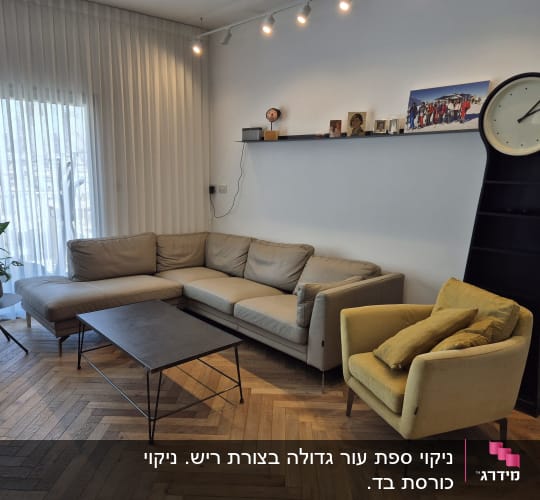 ספה וכורסה בחדר מגורים עם שעון קיר